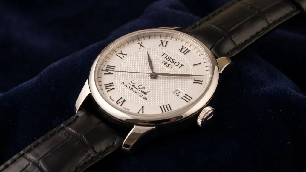 Tissot Le Locle Powermatic 80 white dial with Roman numerals on black crocodile leather strap resting on dark blue velvet