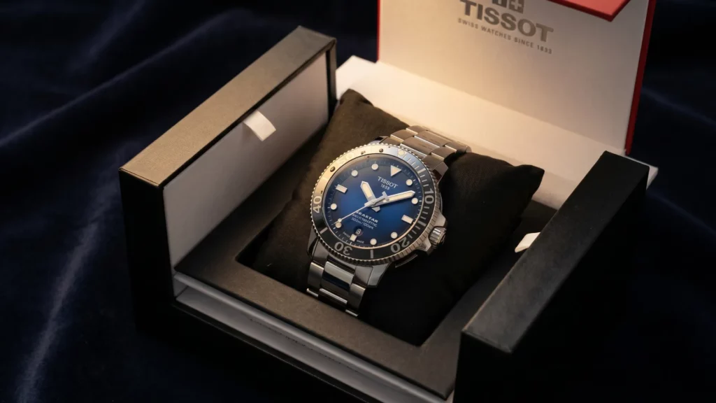Tissot Seastar 1000 blue dial on steel bracelet inside open Tissot box with black interior and red accented lid