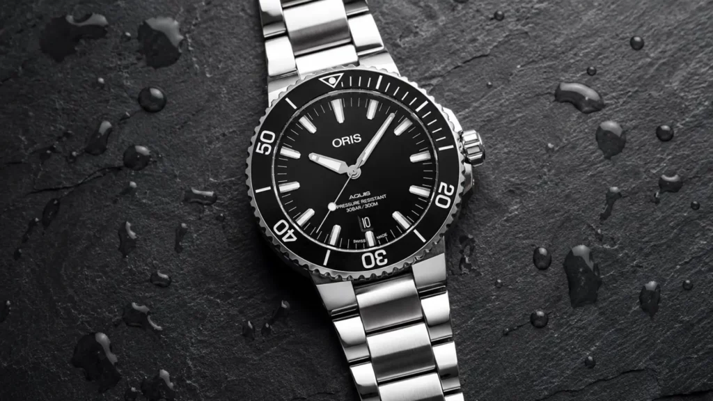 Oris Aquis Date black dial watch with water droplets on dark surface