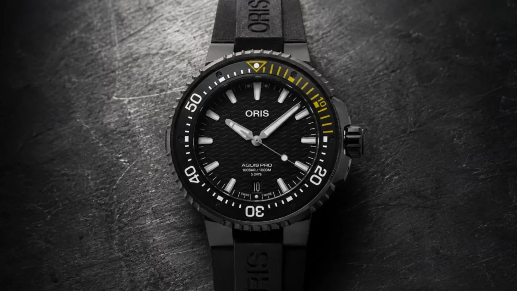Oris Aquis Pro black dive watch on rubber strap against dark textured surface