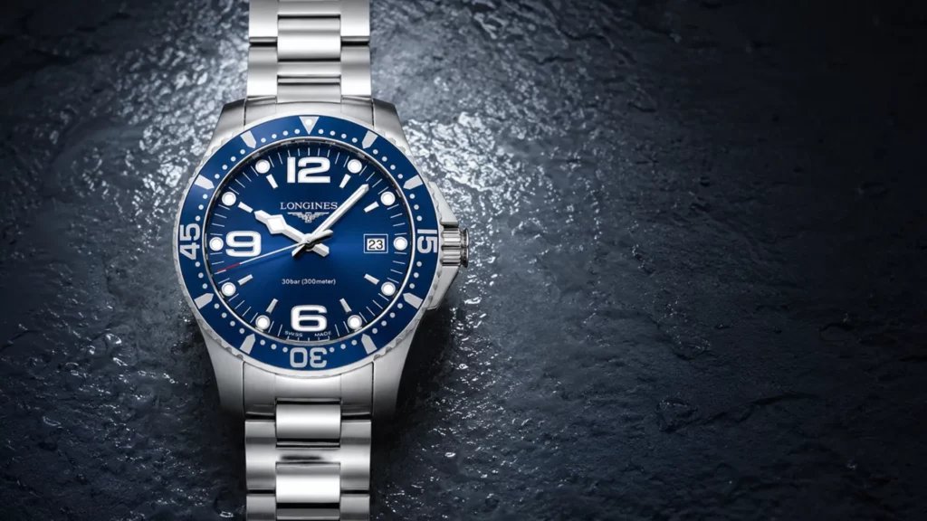 Longines HydroConquest 39mm blue dial watch on steel bracelet against wet dark surface