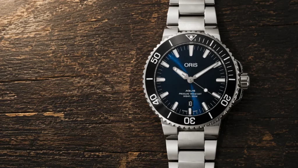 Oris Aquis Date black dial watch on steel bracelet over dark wood