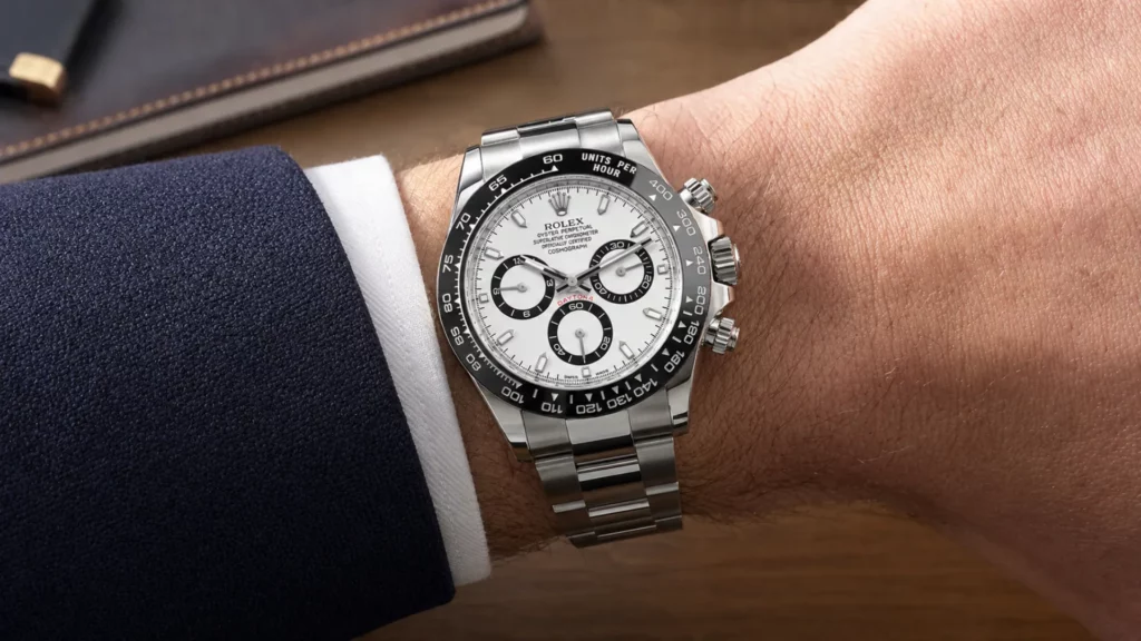Rolex Daytona 116500LN with white panda dial and black ceramic bezel on wrist with navy suit cuff
