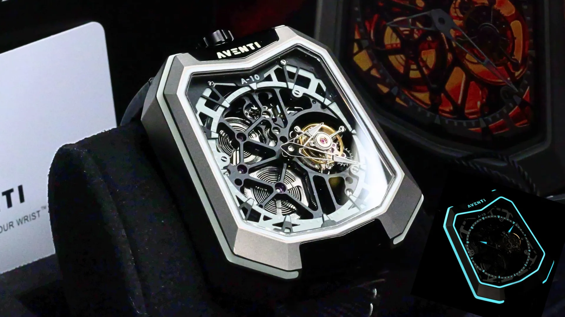 Aventi A-10 tourbillon watch with skeleton dial, angular titanium case, black textile strap, and luminous blue inset on a dark background.