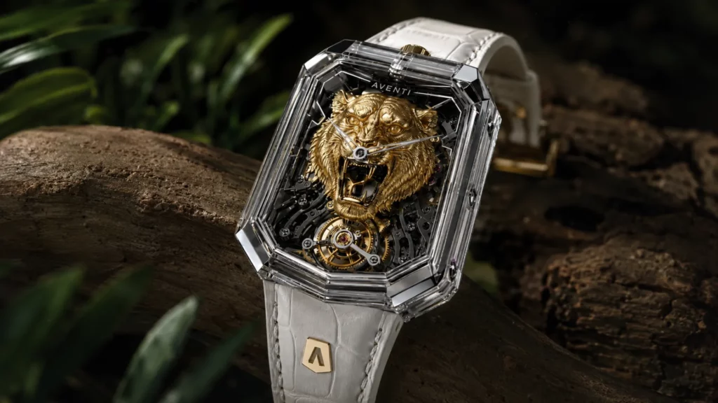 Aventi GT-01S Golden Tiger watch with a clear sapphire-style case, gold tiger dial, white strap, and exposed tourbillon movement on a natural wood background.
