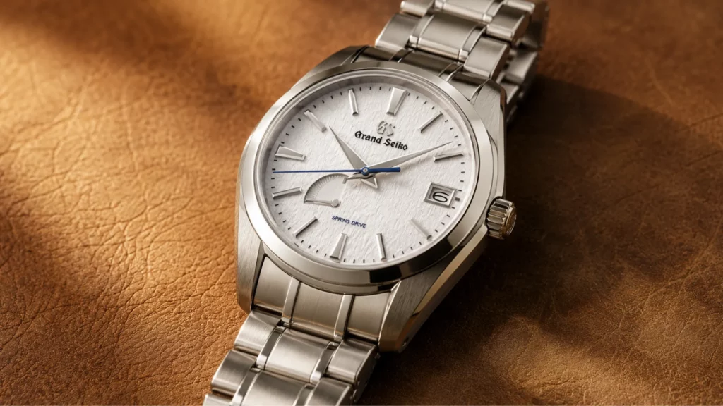 Grand Seiko Heritage SBGA211 Snowflake with textured white dial and Spring Drive power reserve on tan leather background