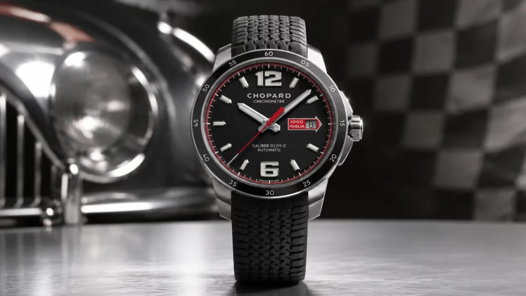 Chopard Mille Miglia chronometer with black dial, red accents, and tire-tread rubber strap beside a vintage car