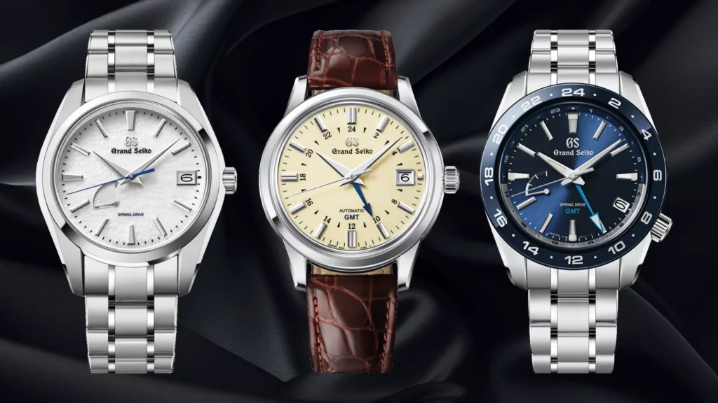 Three Grand Seiko references: Snowflake SBGA211, Elegance GMT SBGM221, and Sport Spring Drive GMT SBGE255 on black silk
