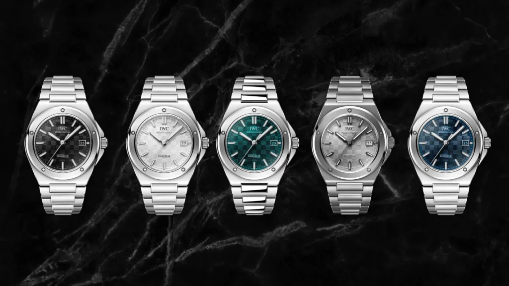 Five IWC Ingenieur Automatic 40 watches shown side by side with black, white, teal, grey, and blue textured dials on a dark marble background.