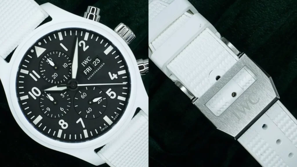 Close-up of IWC Pilot's Chronograph Top Gun Lake Tahoe white ceramic case with black dial beside white rubber strap and engraved buckle on green velvet