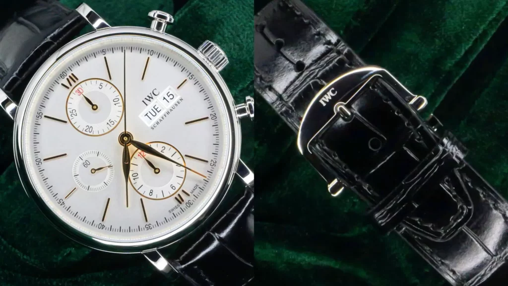 Close-up of IWC Portofino Chronograph with silver dial, day-date window, and black leather strap beside IWC-engraved buckle on green velvet