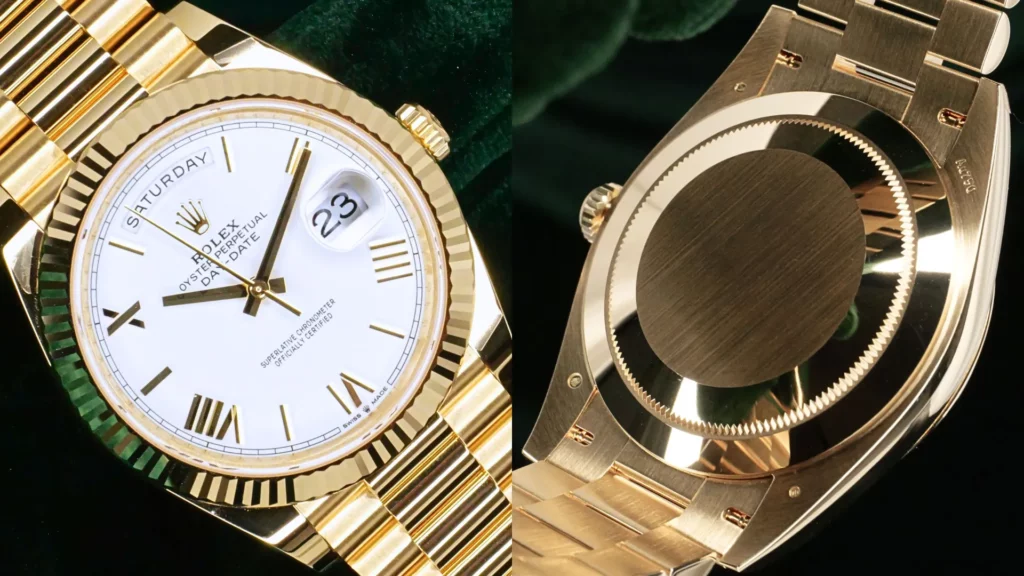 Close-up of Rolex Day-Date 40 yellow gold with white dial, fluted bezel, and Roman numerals beside President bracelet clasp on green velvet