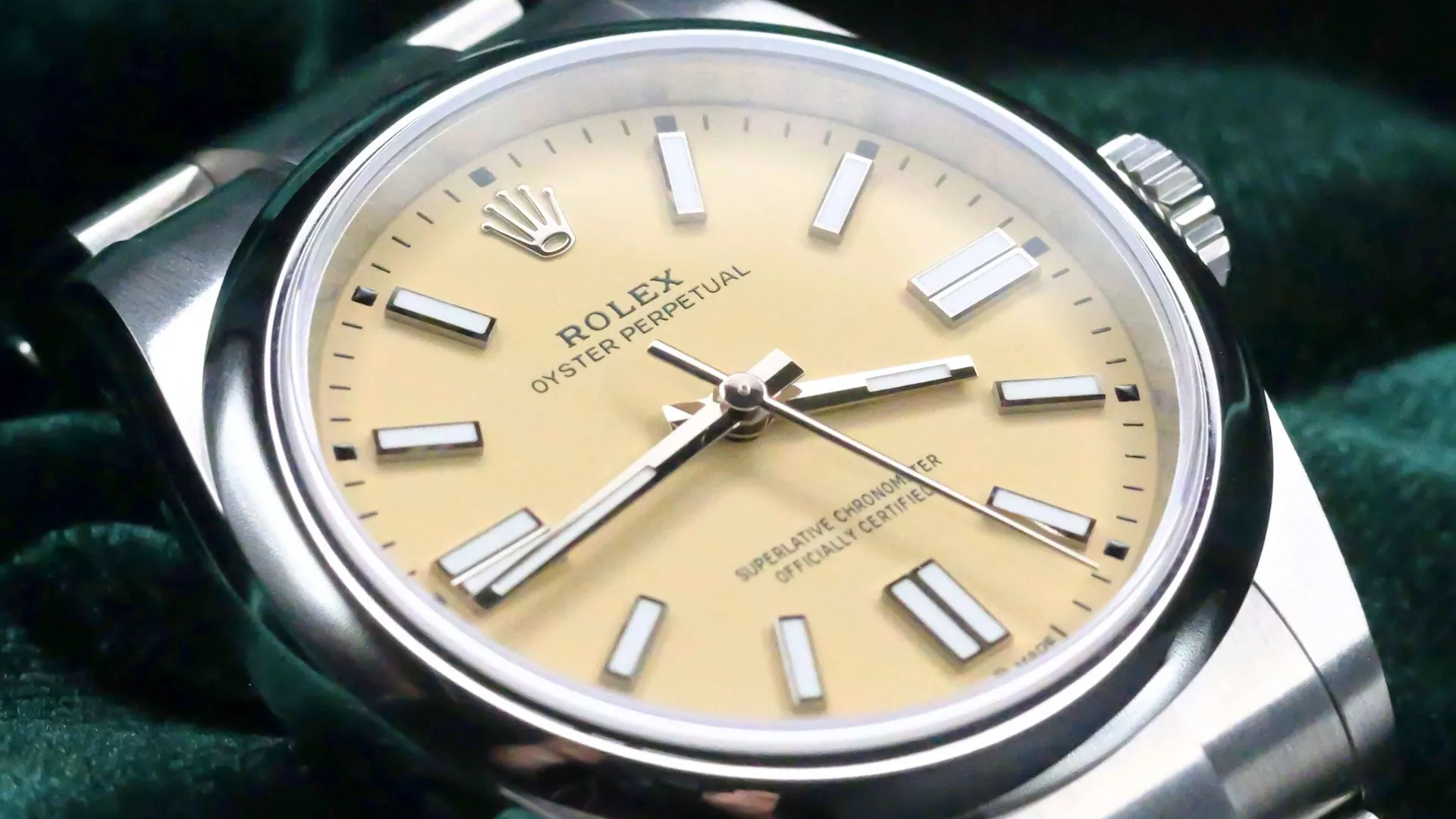Close-up of a Rolex Oyster Perpetual 41 with a beige dial, stainless steel case, baton hour markers, and polished smooth bezel.