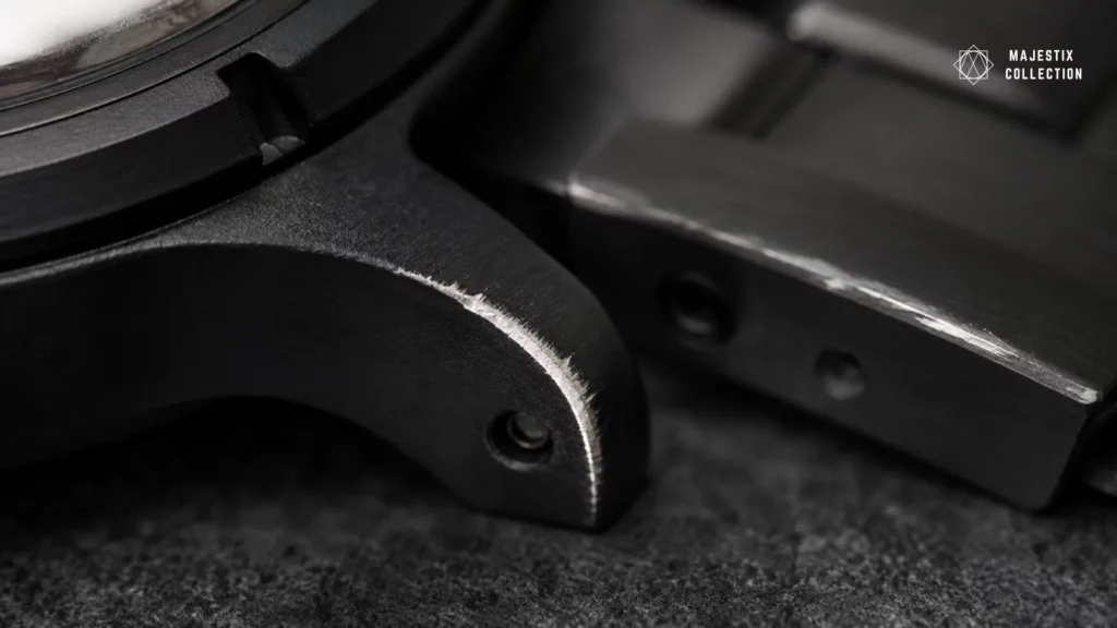 Close-up of Blaken DLC coating wear showing bright steel through black at a worn lug edge