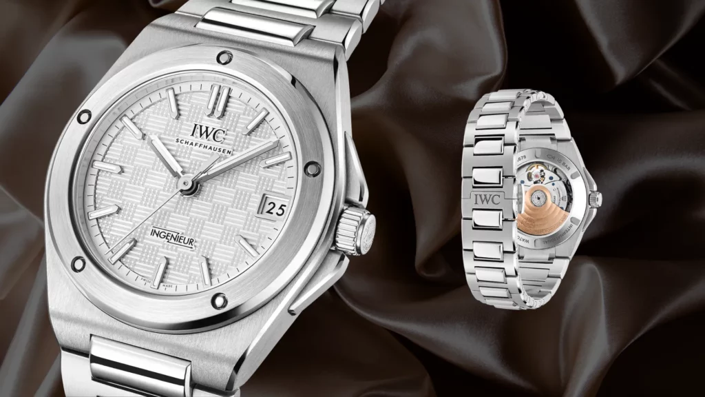 IWC Ingenieur Automatic 35 stainless steel watch with a white textured dial shown beside its exhibition caseback on a dark satin background.