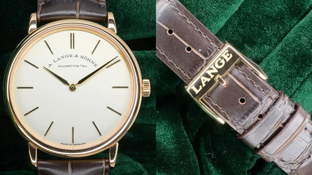 Rose gold A. Lange & Söhne Saxonia Thin with cream dial on a brown alligator strap, alongside its Lange-signed buckle, on green velvet