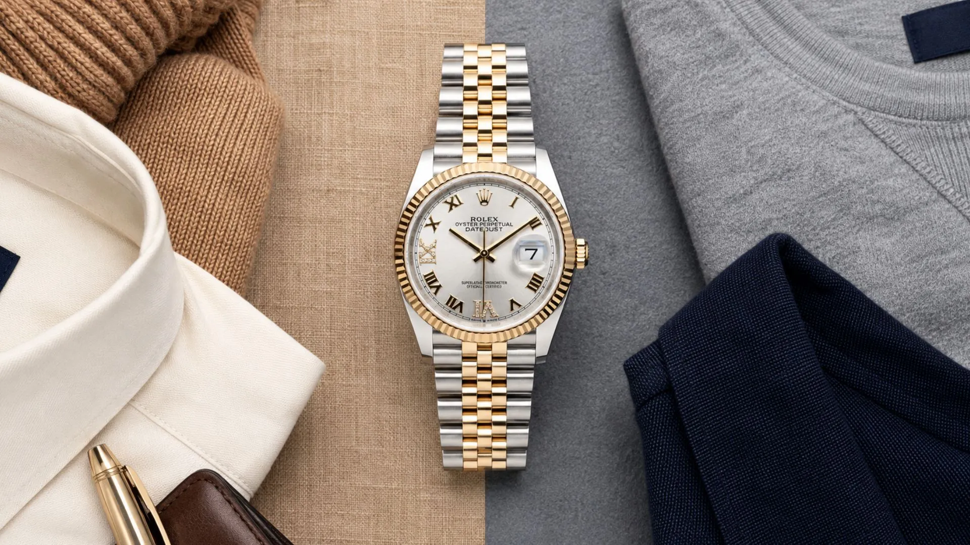 Two-tone Rolex Datejust with silver Roman dial flat lay among cream shirt, camel knit, grey and navy layers