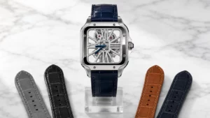Steel Cartier Santos Skeleton on a navy alligator strap flanked by grey, black, tan, and navy leather straps on a marble surface