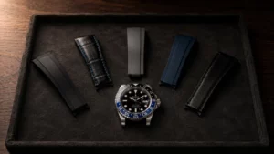 Rolex GMT-Master II Batman with strap colors that suit a black and blue bezel laid out beside it