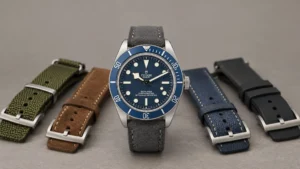 Tudor Black Bay blue dial diver surrounded by green, brown, blue, and black straps on grey