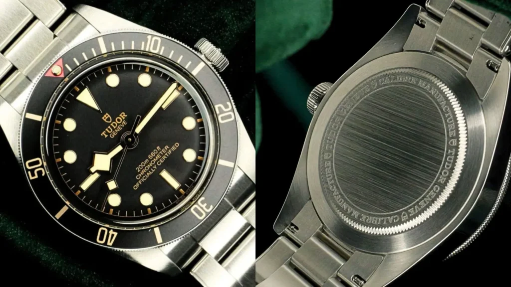 Steel Tudor Black Bay 58 with black dial and gilt accents beside its engraved caseback on green velvet