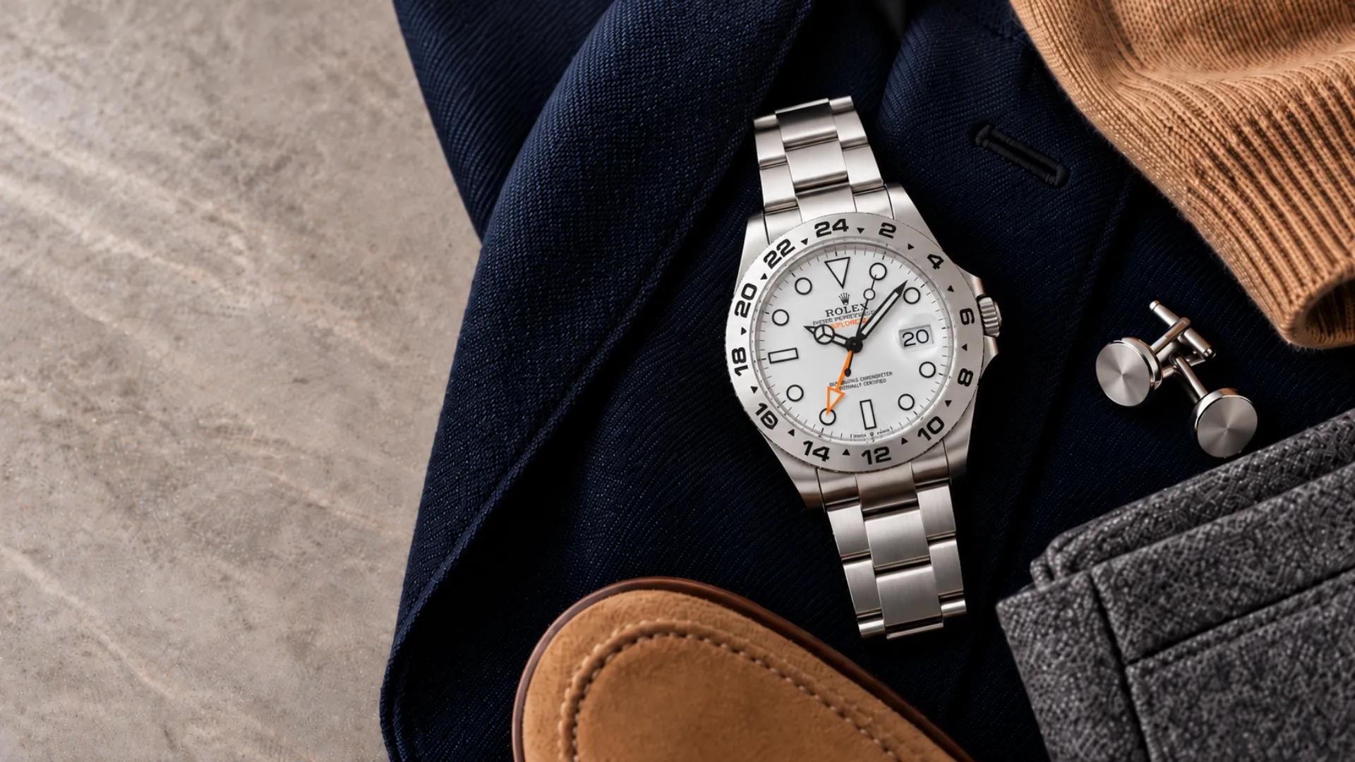 Styling an orange accent watch with a navy suit jacket, gray flannel, and tan suede loafers